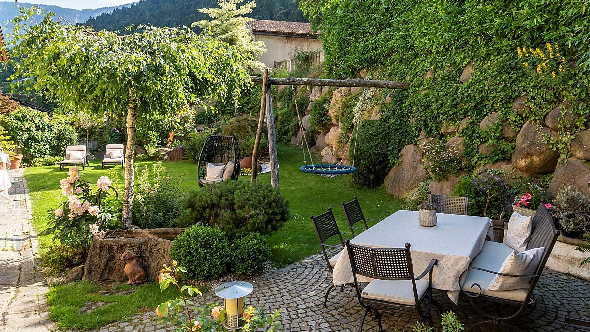 Onze tuin met ligweide, nestschommel en zitgelegenheid