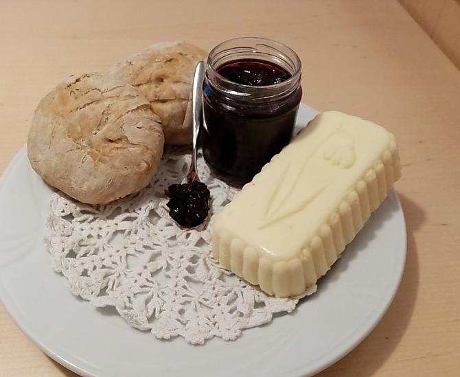 Voor een heerlijk ontbijt: zelfgebakken brood met verse boerenboter en lekkere bosbessenjam.