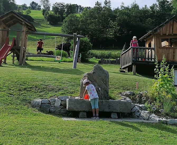 Kruidentuin met waadbassin en daarachter is de speelplaats.