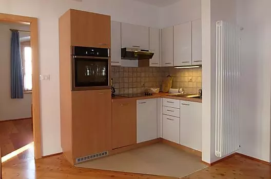 De keukenhoek in de woonkamer van vakantiewoning Abendsonne is uitgerust met vaatwasser en oven.