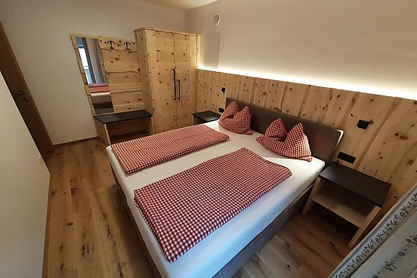 Doppelbettzimmer aus eigenem Zirbenholz kombiniert mit kuscheligem Boxspringbett