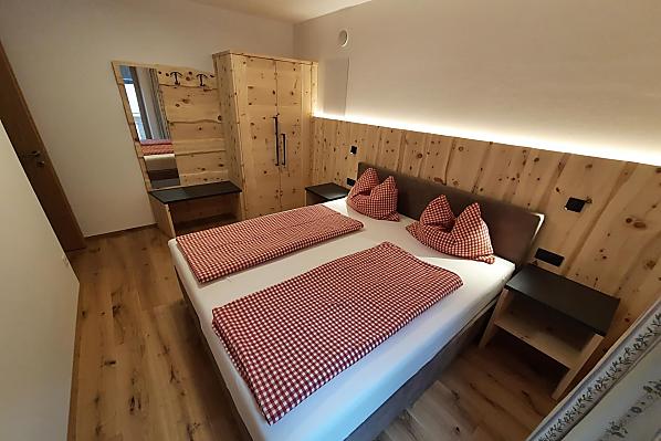 Doppelbettzimmer aus eigenem Zirbenholz kombiniert mit kuscheligem Boxspringbett
