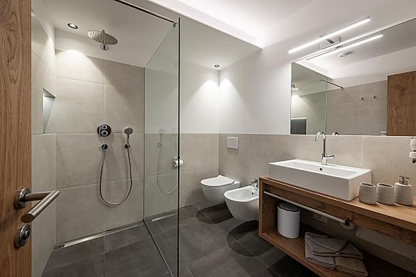 Bad mit Waschbecken, Föhn, großer Dusche mit Regenbrause, Bidet, WC sowie wohlig-warmer Bodenheizung.