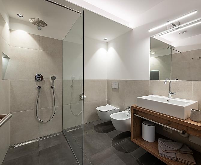 Bad mit Waschbecken, Föhn, großer Dusche mit Regenbrause, Bidet, WC sowie wohlig-warmer Bodenheizung.