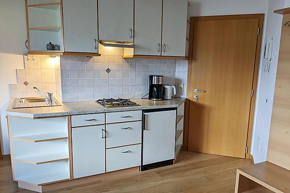 Küchenblock im Wohnraum komplett eingerichtet, u.a. mit Spülmaschine, Kaffeemaschine, Wasserkocher, Toaster.