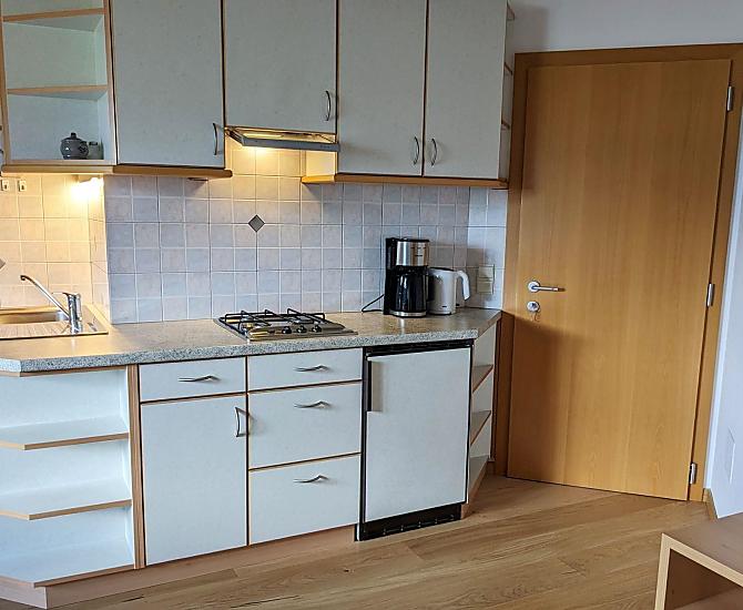 Küchenblock im Wohnraum komplett eingerichtet, u.a. mit Spülmaschine, Kaffeemaschine, Wasserkocher, Toaster.