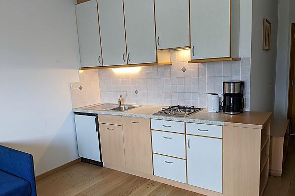 Komplett eingerichteter Küchenblock im Wohnraum mit Spülmaschine, Kaffeemaschine, Wasserkocher und Toaster