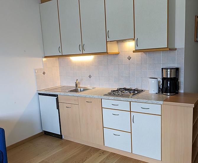 Komplett eingerichteter Küchenblock im Wohnraum mit Spülmaschine, Kaffeemaschine, Wasserkocher und Toaster
