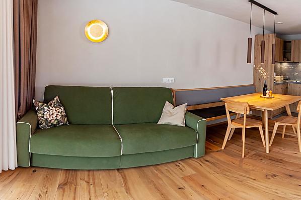 Die geräumige Wohnküche mit Schlafcouch und großem Panoramafenster