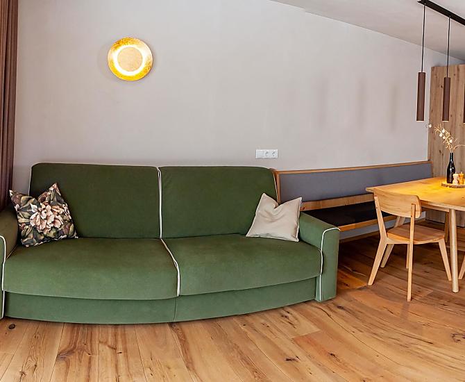 Die geräumige Wohnküche mit Schlafcouch und großem Panoramafenster