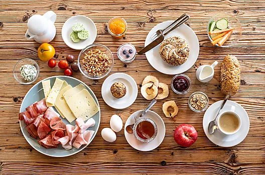 Unser reichhaltiges Bauernhoffrühstück, serviert auf der Sonnenterrasse oder als Korb zur Selbstkonsumation an die Wohnungstür geliefert