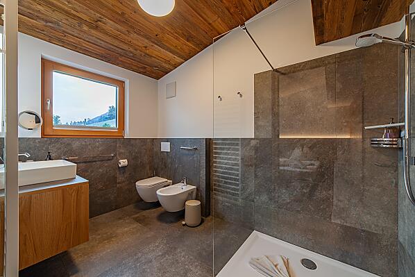 Badezimmer mit Fußbodenheizung, großer Dusche, WC, Bidet, Kosmetikspiegel, Fön, Handtuchhalter, Fenster und Abzug