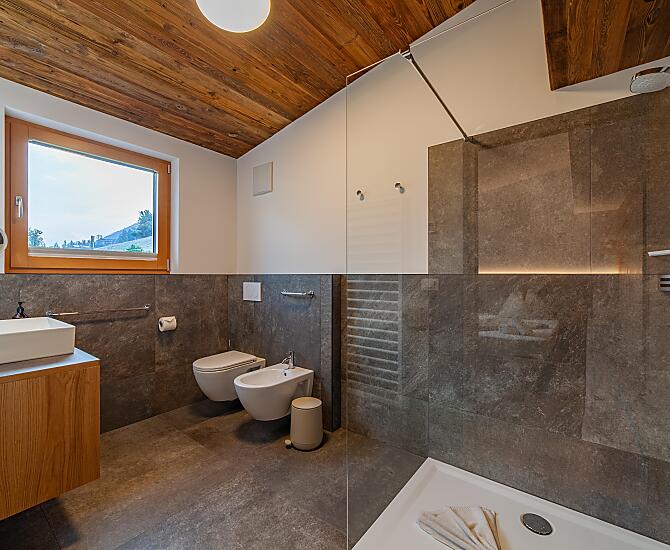 Badezimmer mit Fußbodenheizung, großer Dusche, WC, Bidet, Kosmetikspiegel, Fön, Handtuchhalter, Fenster und Abzug