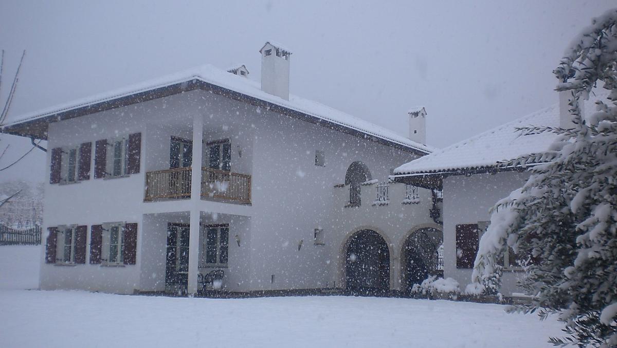 Ons huis in het winterlandschap tijdens een sneeuwbui